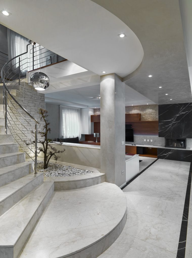 modern living room interior in the foreground the masonry staircase with steel railing on the background the fireplace